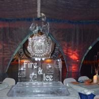 Ice sculpture for Fire & Ice event with a plaque and glowing red and blue lights on a table