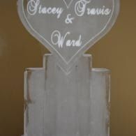 White heart-shaped sign reading “Stacey & Travis” on a frosted stand.