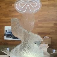 Clear glass sculpture on a wooden floor, with a round ceiling light reflected behind it