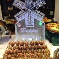 Snowflake-shaped dessert display with skewered snacks arranged in rows on a buffet table