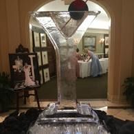 Ice sculpture centerpiece with a red ornament in a banquet hall.