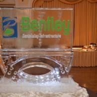 Bentley-branded clear award or trophy on a table with gold curtains in the background