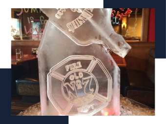 Clear etched glass bottle or trophy with “Old No. 7” logo on a table in a dim bar.