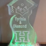 Glowing green acrylic award plaque engraved “Tyrinie & Diamond” with a large H and graduation cap design