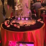 Red-lit buffet table with a dessert display and decorative centerpiece at an indoor event