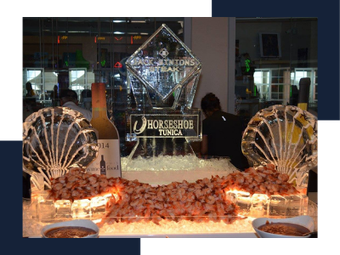 Decorative seafood buffet display with a black sign, floral accents, and two fan-shaped shell decorations
