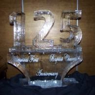 Silver “125” ice sculpture with cursive names on a black table display.