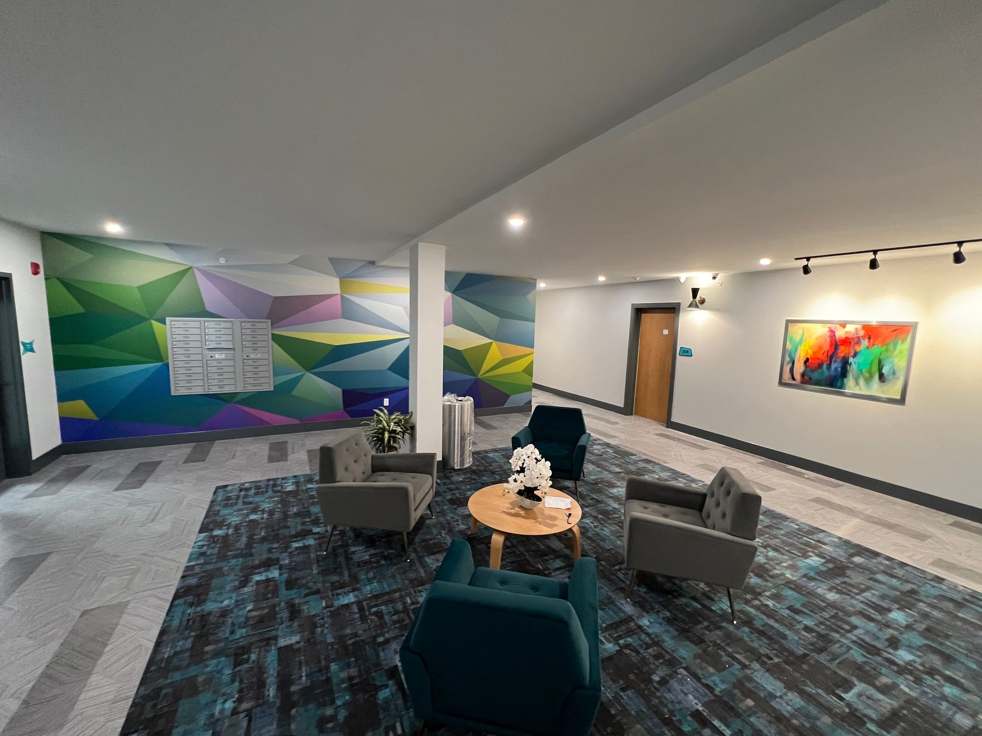 Lobby with seating area, colorful geometric wall art, and a painting.