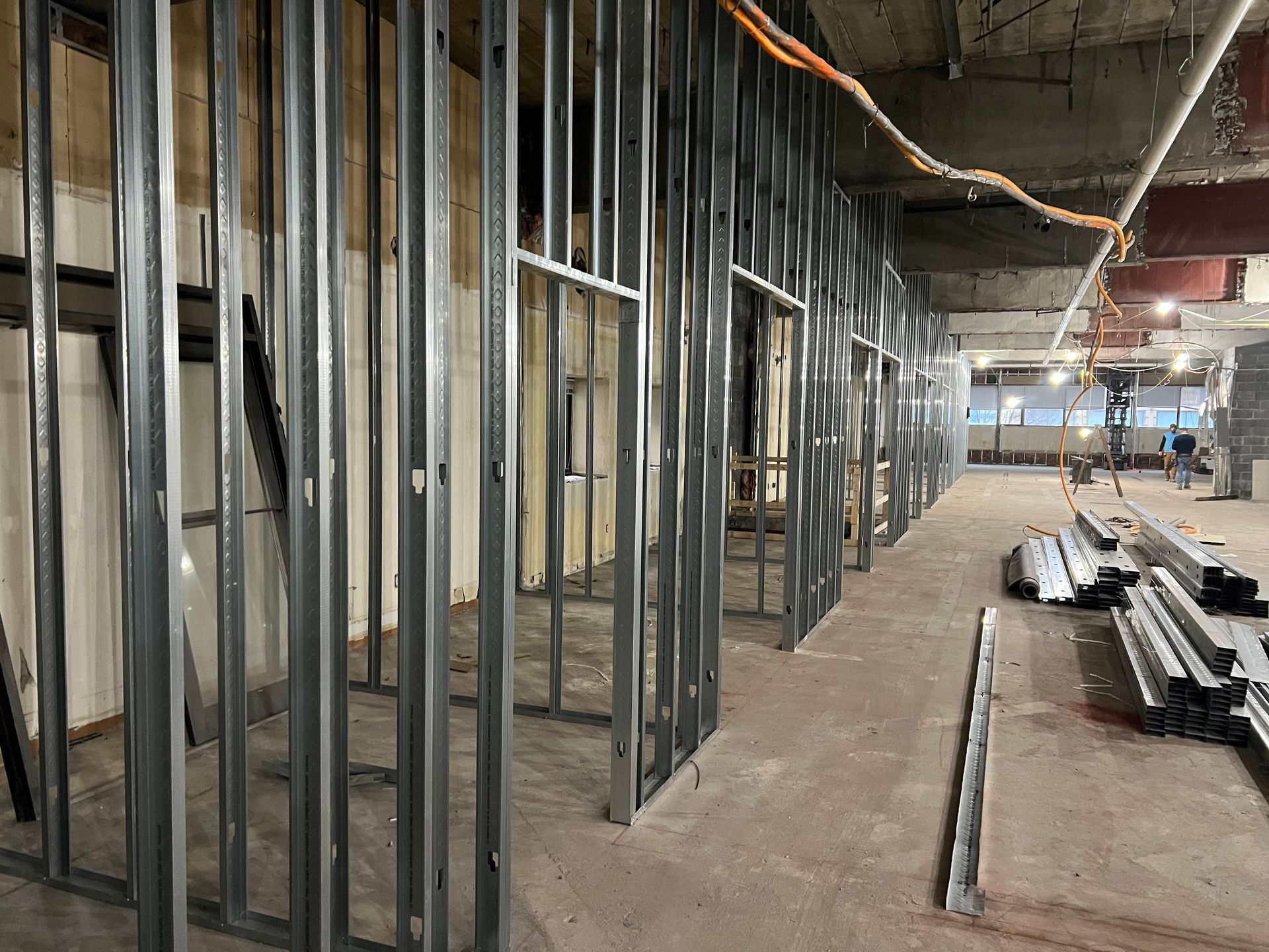 Interior construction: Metal studs forming walls and doorways in a building's unfinished interior. Concrete floor.