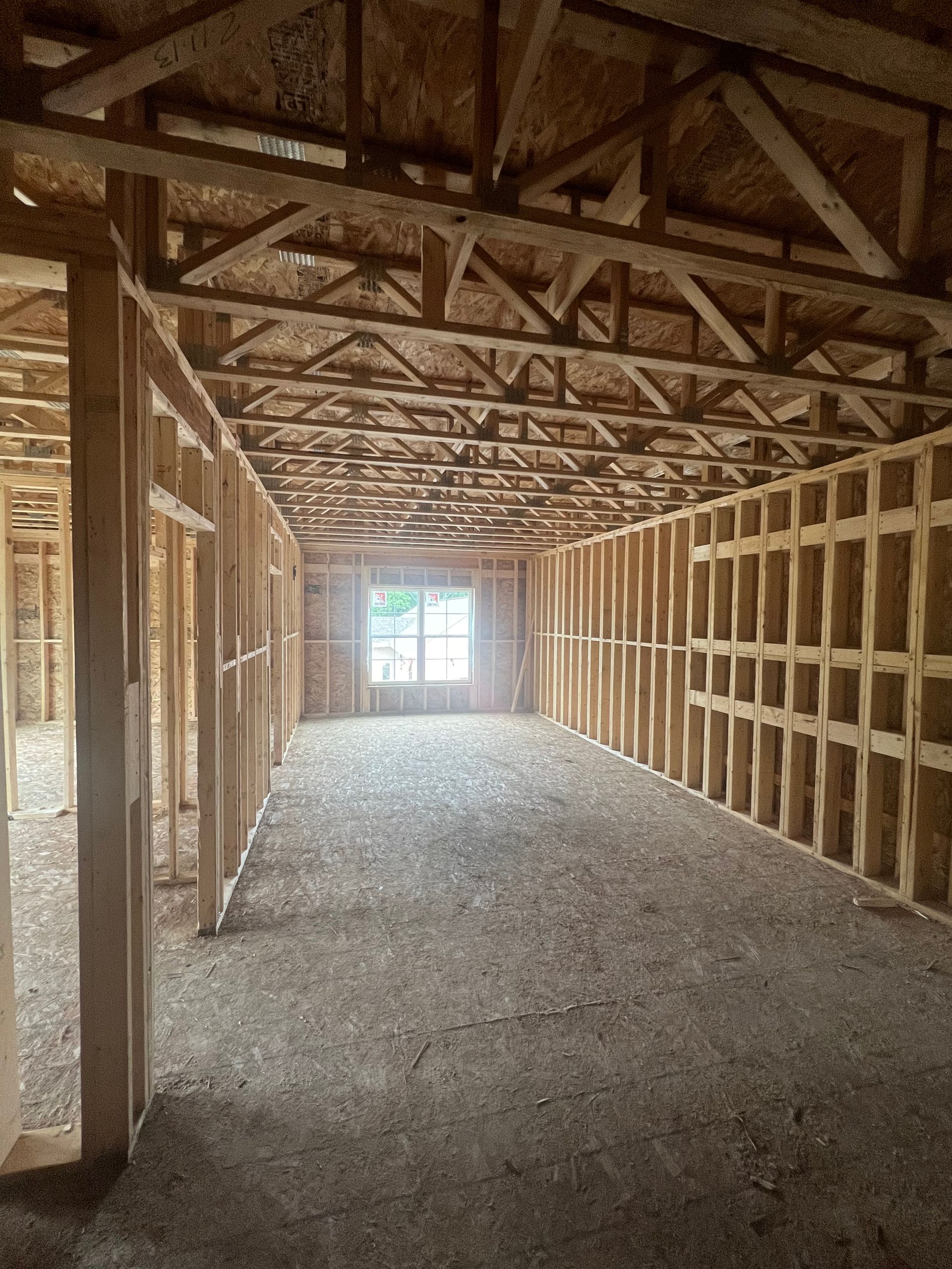 Interior of a building under construction, showing wooden frame walls and ceiling.