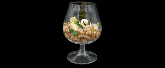 Ein Glas gefüllt mit Kichererbsen, Kräutern und anderen Zutaten auf schwarzem Hintergrund.