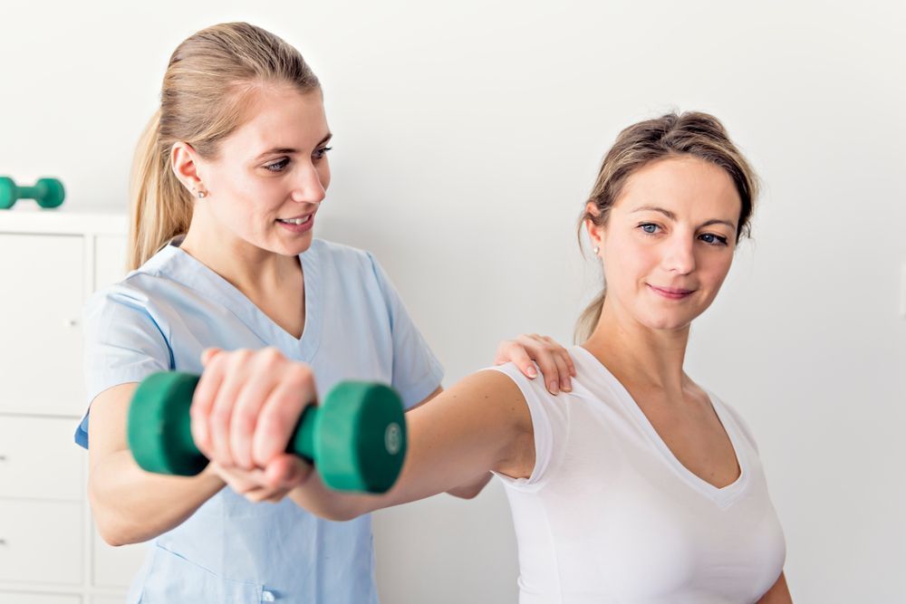 Therapist Assisting a Patient With Arm Exercises — PhysioCare Townsville in Thuringowa Central, QLD