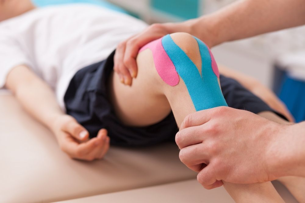 Knee With Colored Tape Being Examined — PhysioCare Townsville in Hyde Park, QLD