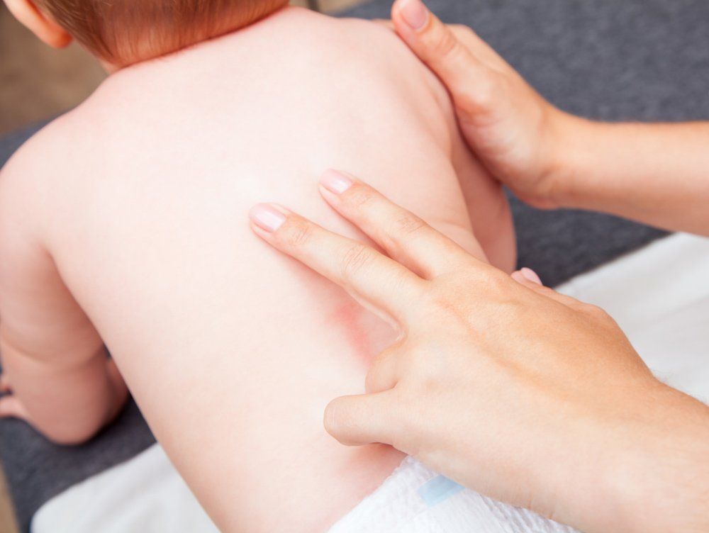 Hands Gently Touching a Baby's Back, Possibly for Massage — PhysioCare Townsville in Thuringowa Central, QLD
