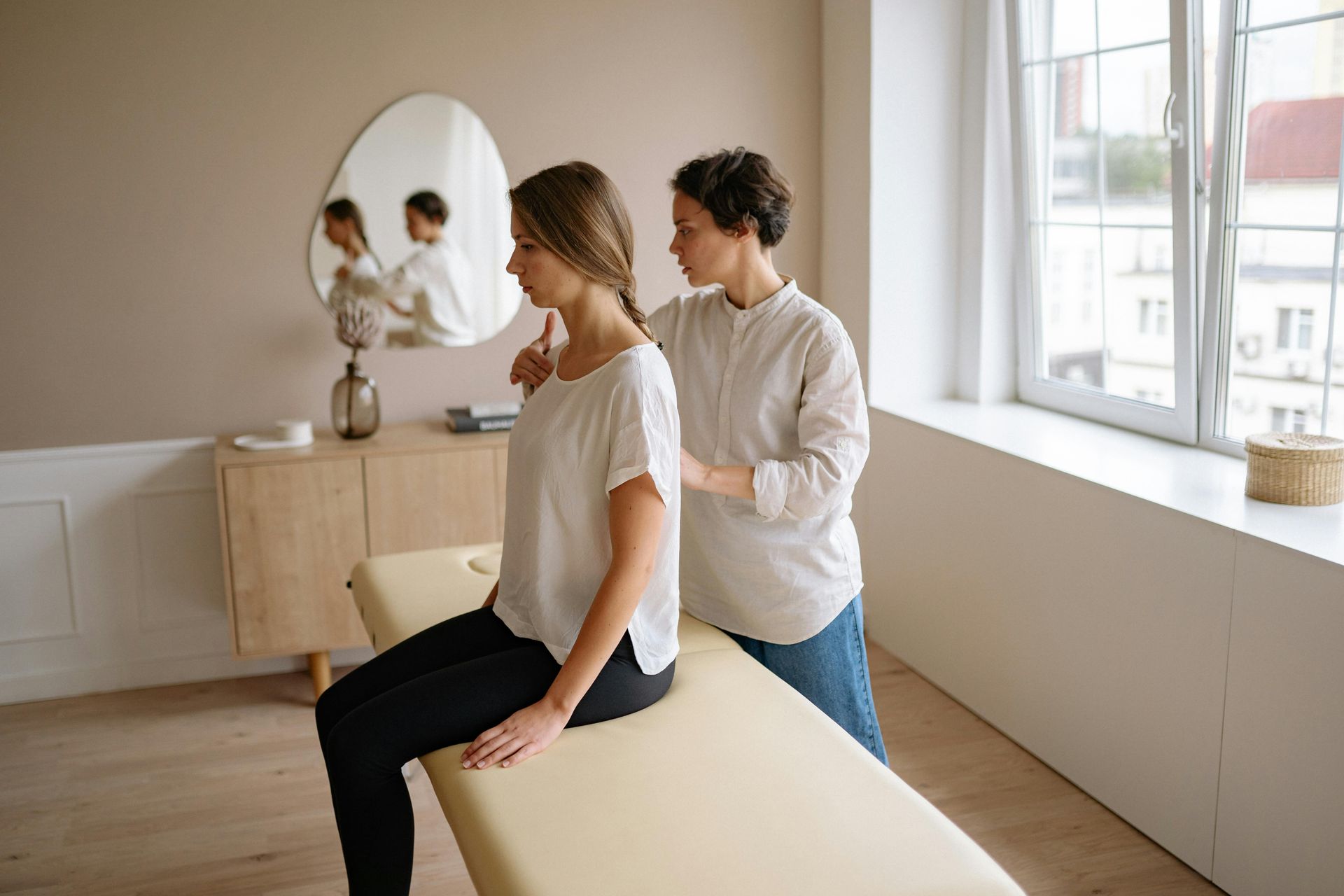 Physical Therapist Assisting a Person With a Shoulder Exercise — PhysioCare Townsville in Thuringowa Central, QLD