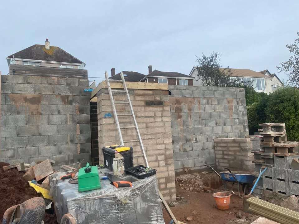A new cavity block wall built on site with ladder and tools