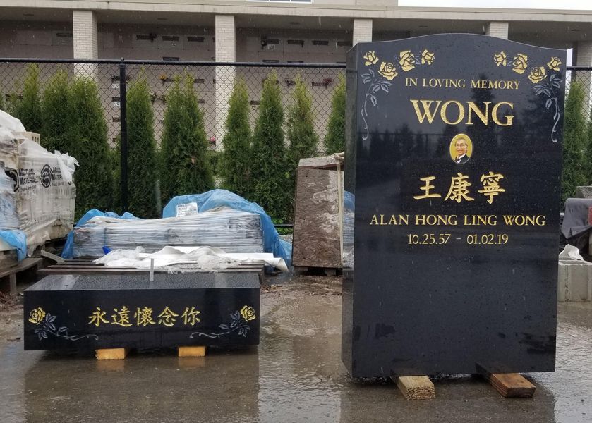 A gravestone for wong is sitting in front of a building