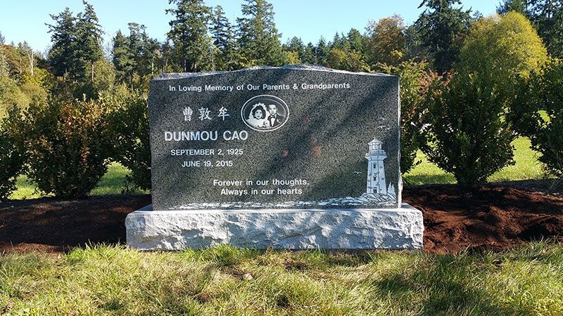 A gravestone in a cemetery with trees in the background.