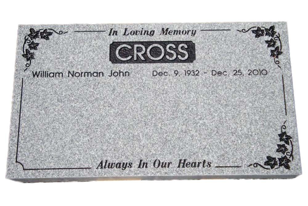 A gravestone for william norman john cross is sitting on a white surface.