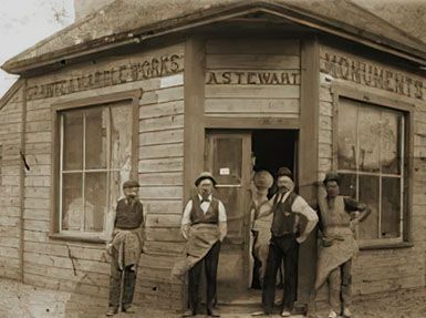 A group of men standing in front of a building that says monuments