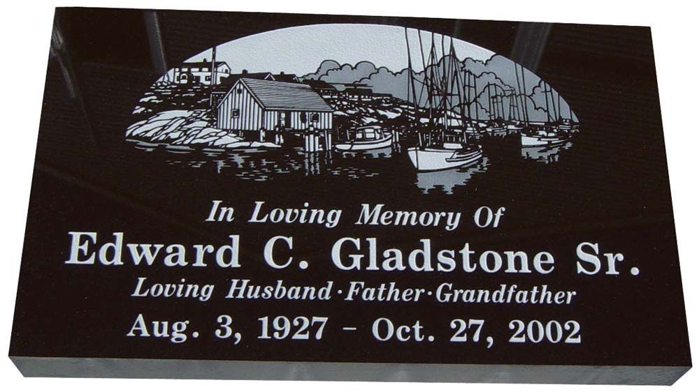 A flat, dark impala (dark grey), headstone with white flowers, hummingbird and butterflies. 