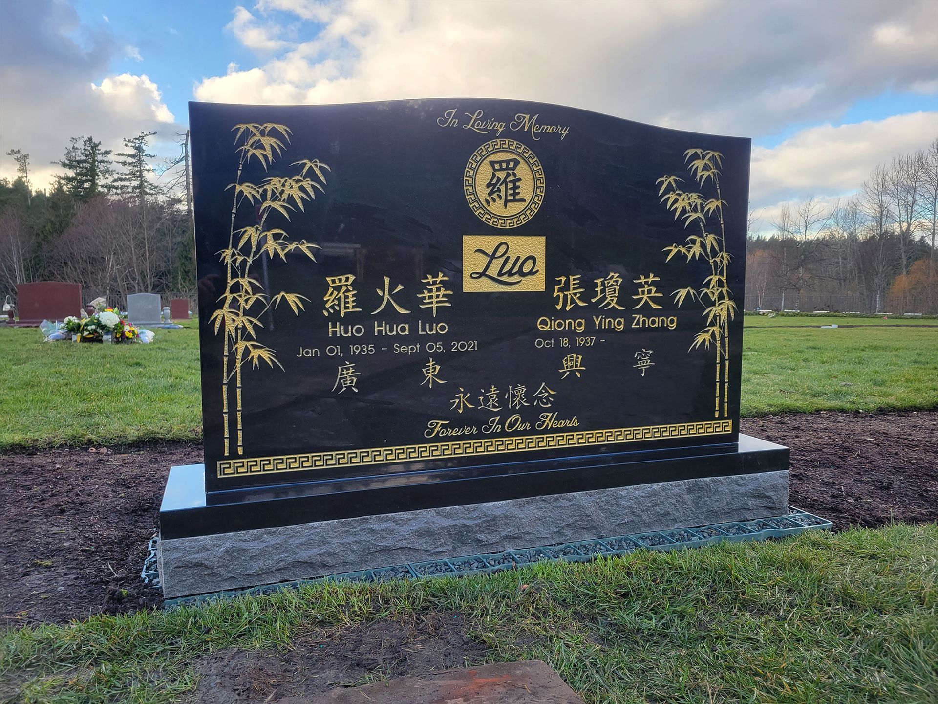 A black gravestone with chinese writing on it