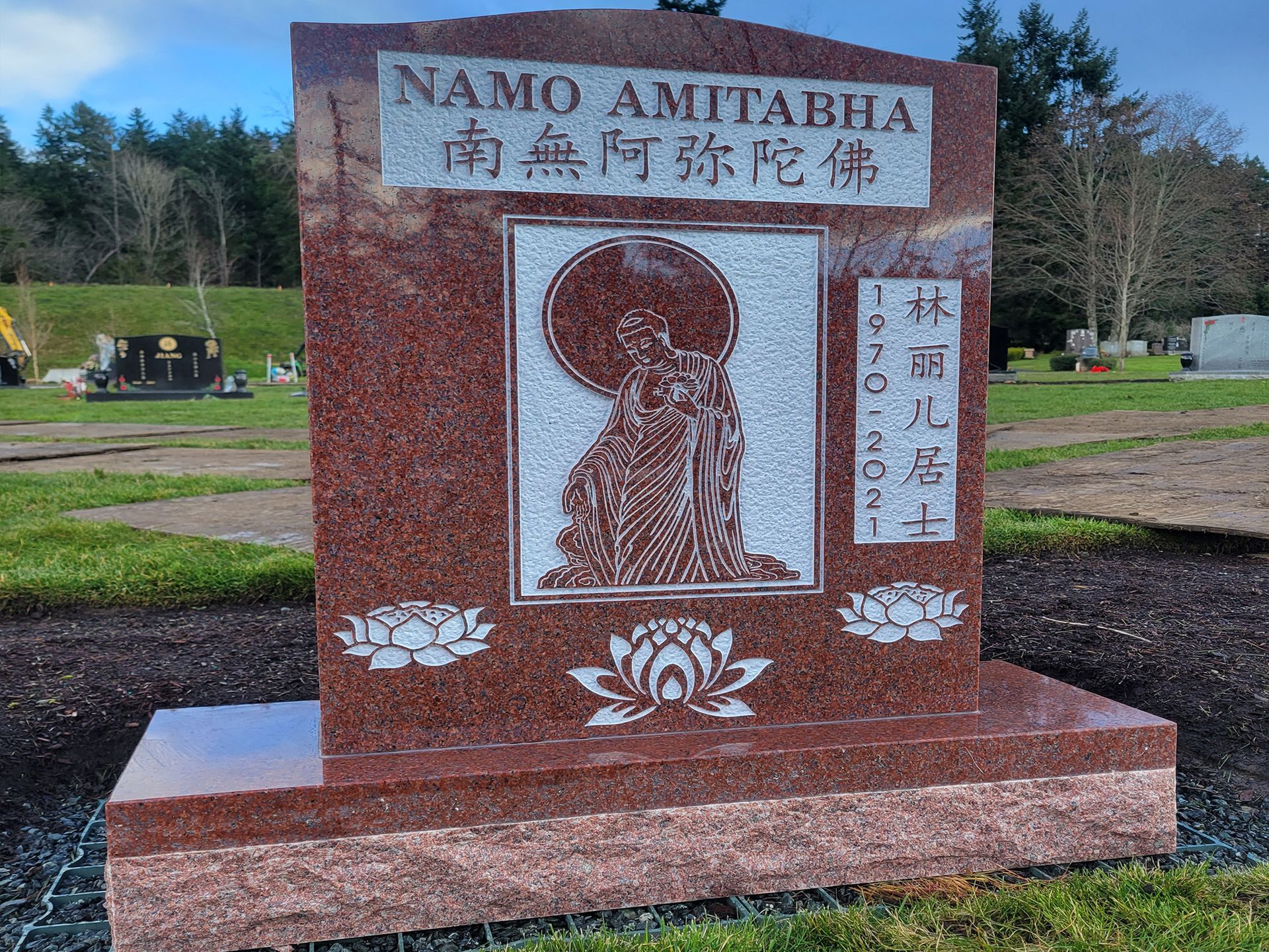 A gravestone in a cemetery that says ' namo amitabha ' on it