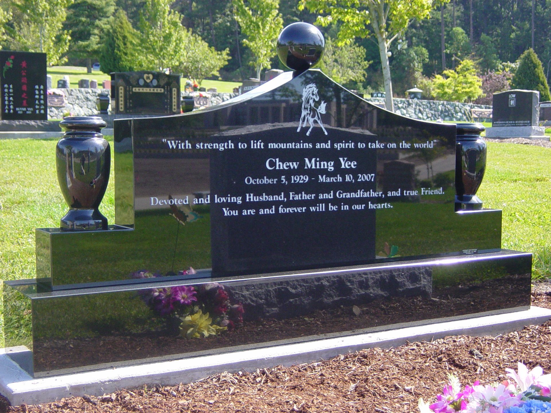 A black gravestone with the name chew ming yao on it
