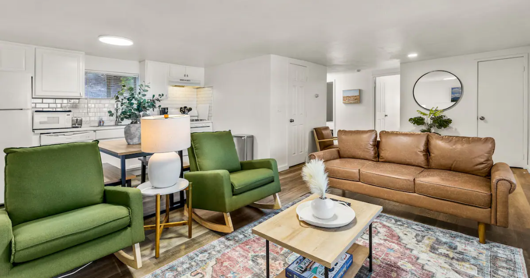 A living room with a couch , chairs , and a coffee table.