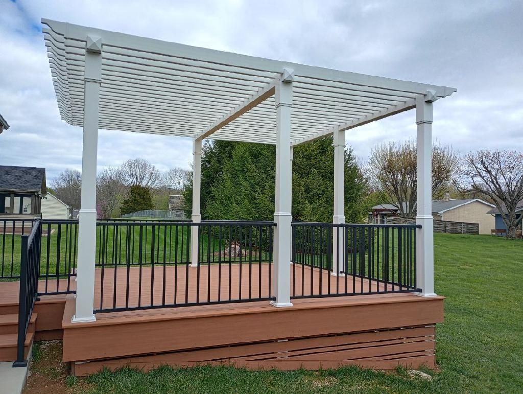 Wooden backyard gazebo with white pergola roof and black railing on a raised deck