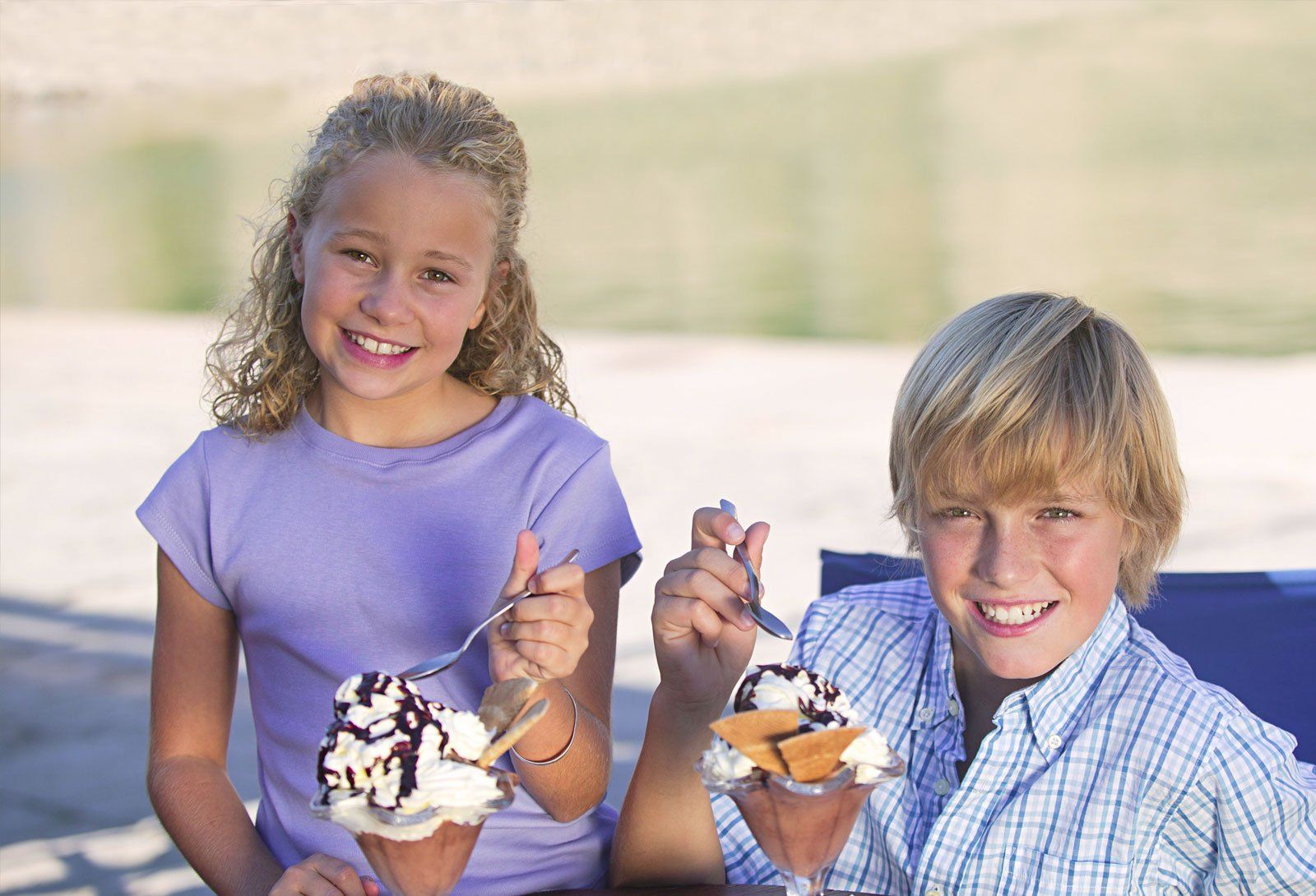 Two children outdoors holding ice cream cups