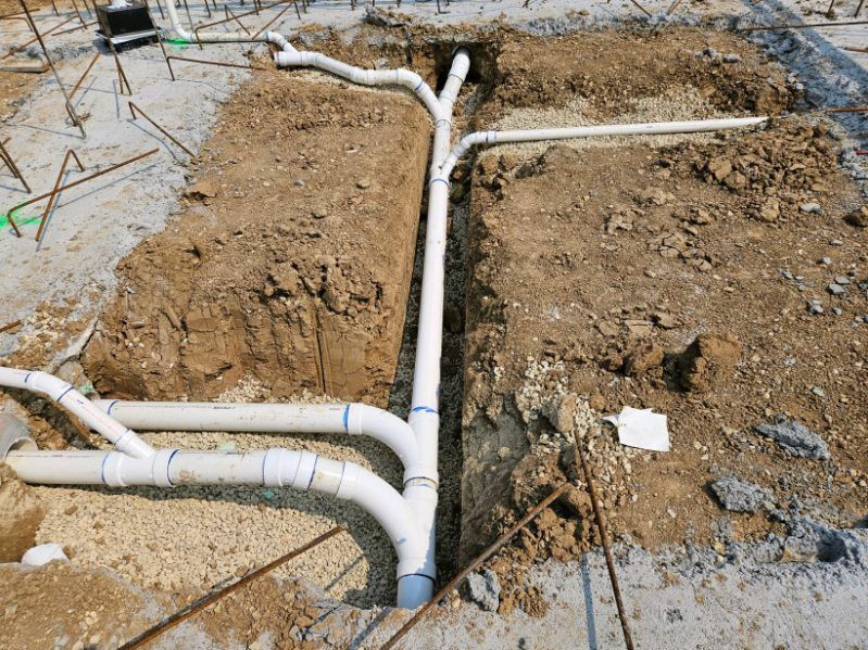 A bunch of pipes are being installed in the dirt.