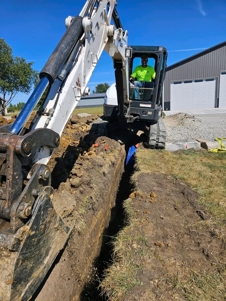 A man is driving a bulldozer digging a hole in the ground.