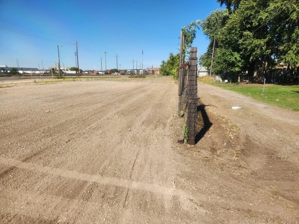 A dirt road with a fence in the middle of it