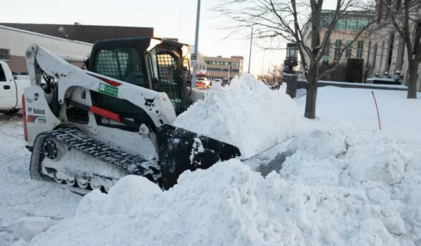 Bobcat snow plow pushing a large pile of snow.