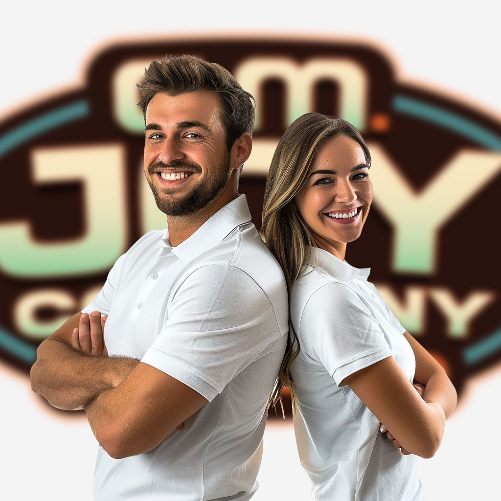 A male and woman staff standing back to back in front of C.M. Joy Company signage