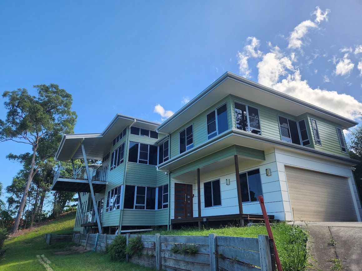 A large house with a lot of windows is sitting on top of a hill.