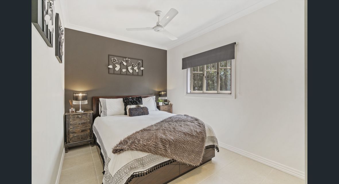 A bedroom with a bed, nightstands, a window and a ceiling fan — Painter In Sunshine Coast, QLD