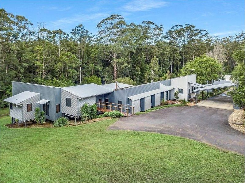 A large house is sitting on top of a lush green field surrounded by trees — Painter In Sunshine Coast, QLD