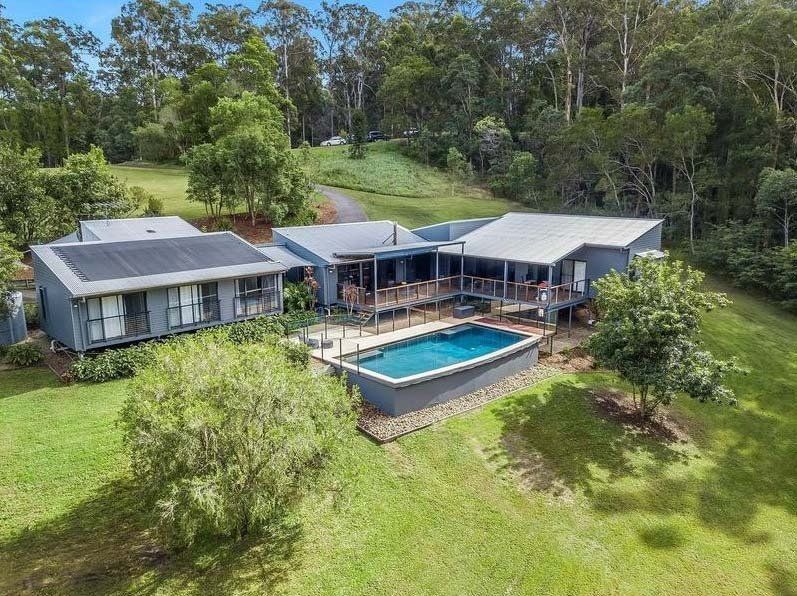 An aerial view of a house with a large swimming pool surrounded by trees — Painter In Sunshine Coast, QLD
