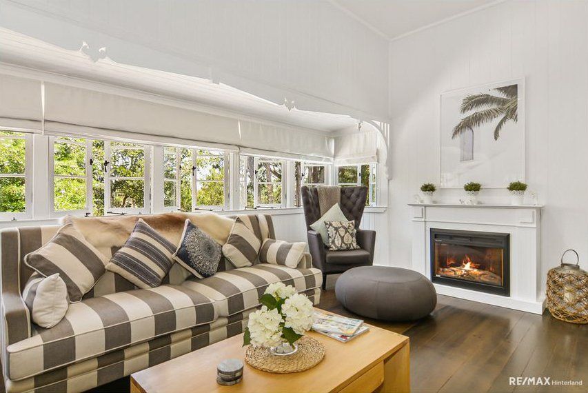 A living room with a striped couch, chair , coffee table and fireplace — Painter In Sunshine Coast, QLD