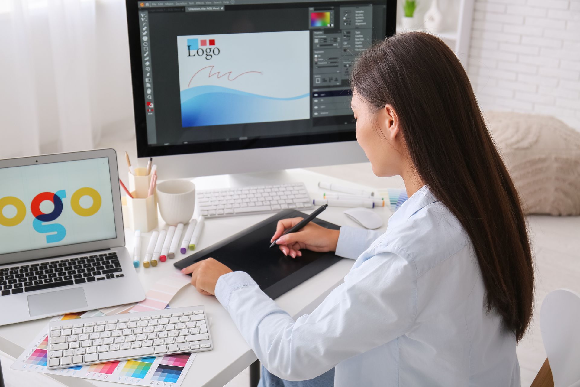 A woman is sitting at a desk working on a computer.