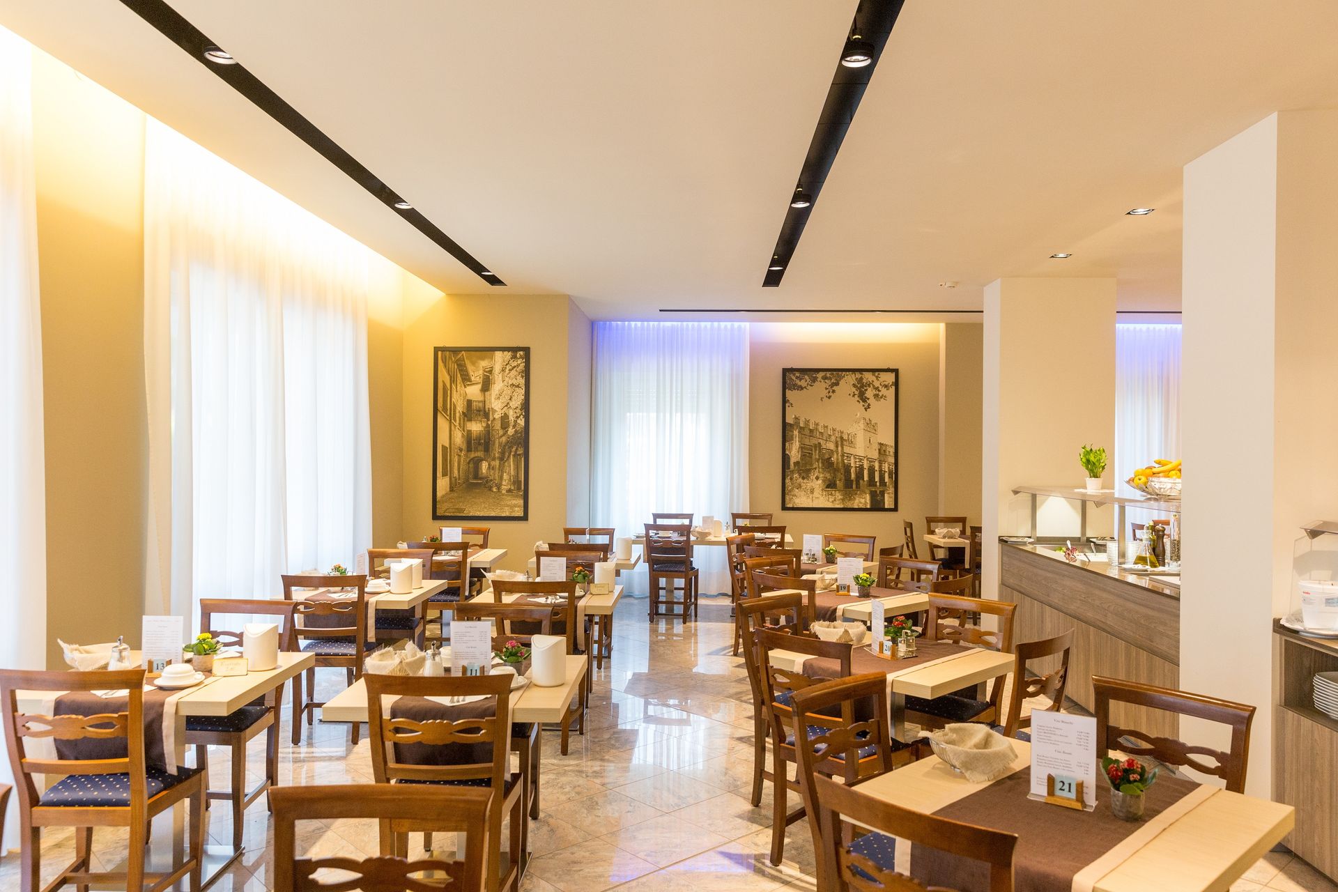 Bright modern restaurant dining room with wooden tables, chairs, and soft warm lighting