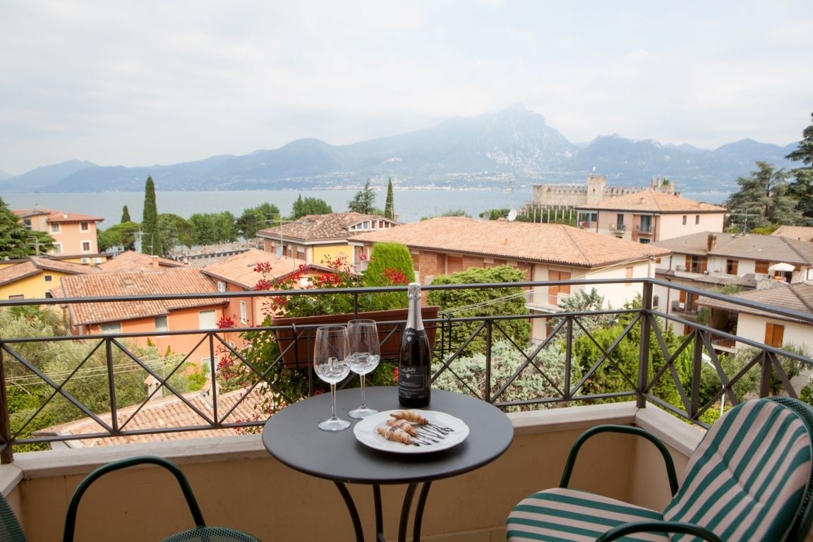 Balcony table with wine and dessert overlooking a lake and distant mountains
