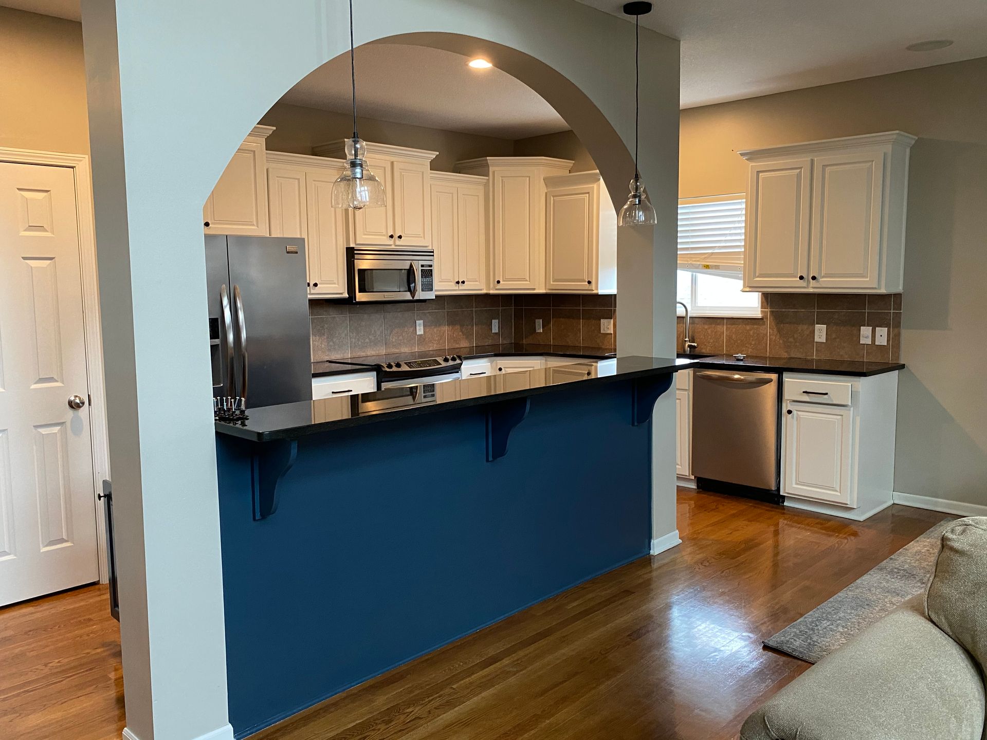 A kitchen with white cabinets and stainless steel appliances and a blue counter top.