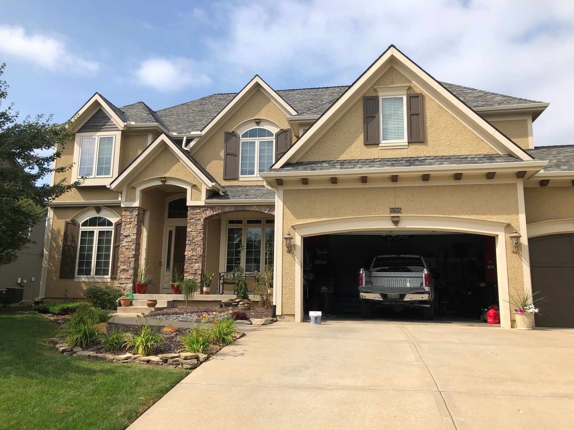 A large house with a truck parked in the garage
