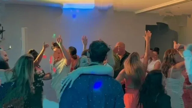 A group of people are dancing in a room at a party.