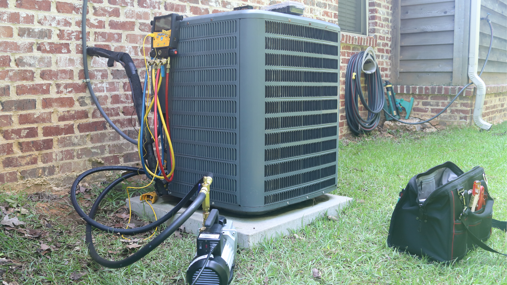 A white air conditioner is mounted on the side of a building.