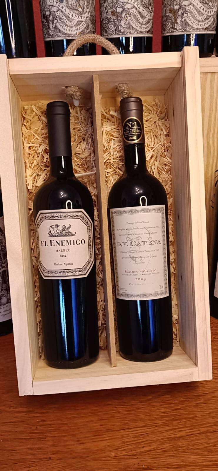 Dos botellas de vino en una caja de regalo de madera sobre una mesa de madera.
