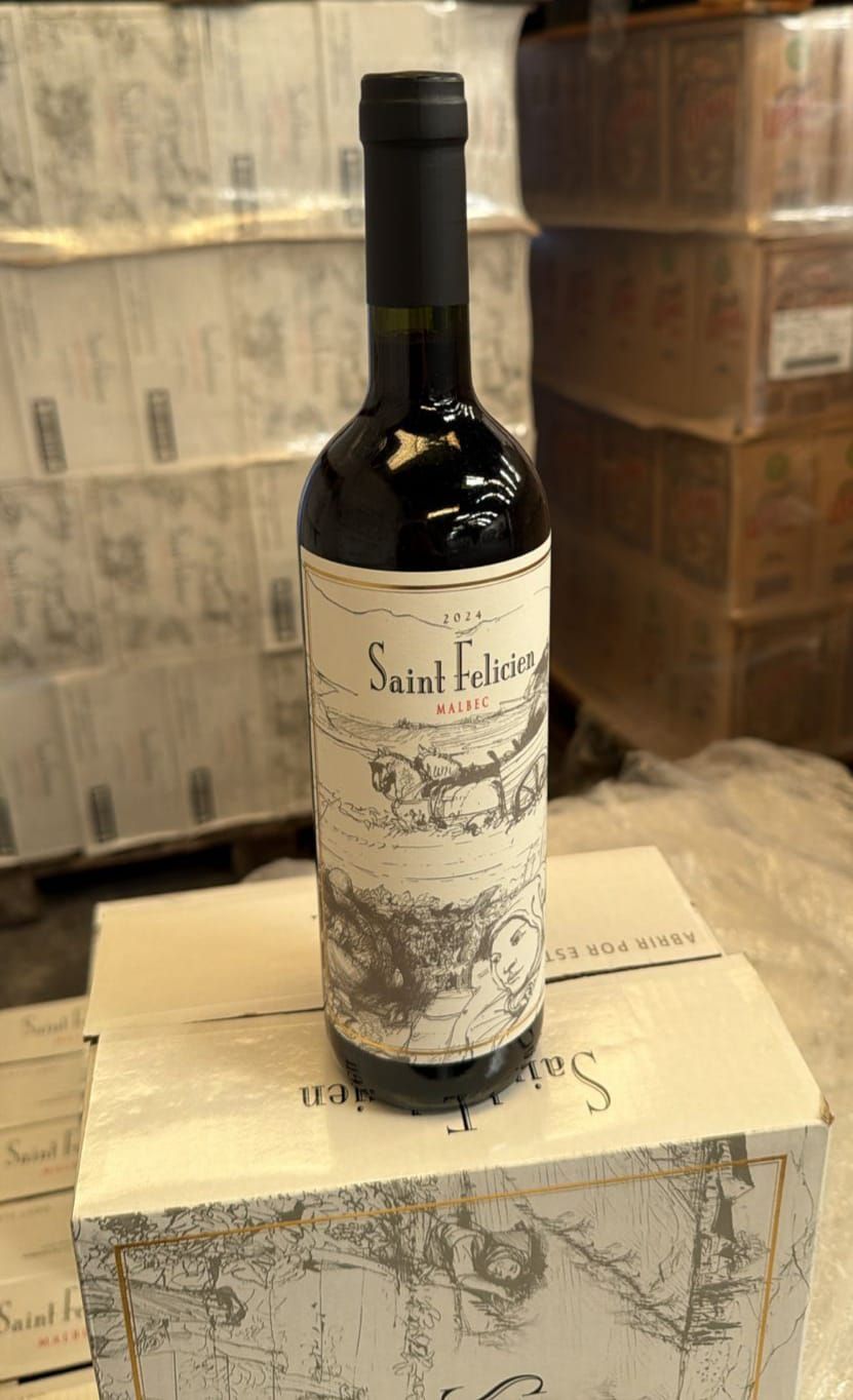 Botella de vino con etiqueta blanca en una caja a juego, expuesta en un almacén.